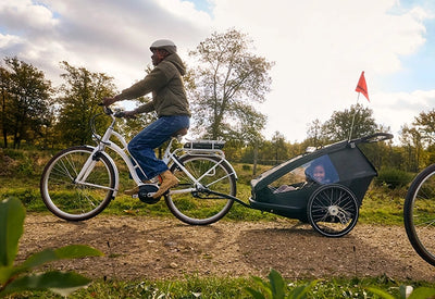 Mother cycling with child and dog in the modular Croozer Yuuna