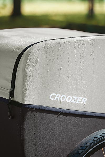 Croozer bike trailer with water droplets - weatherproof design and water-resistant construction