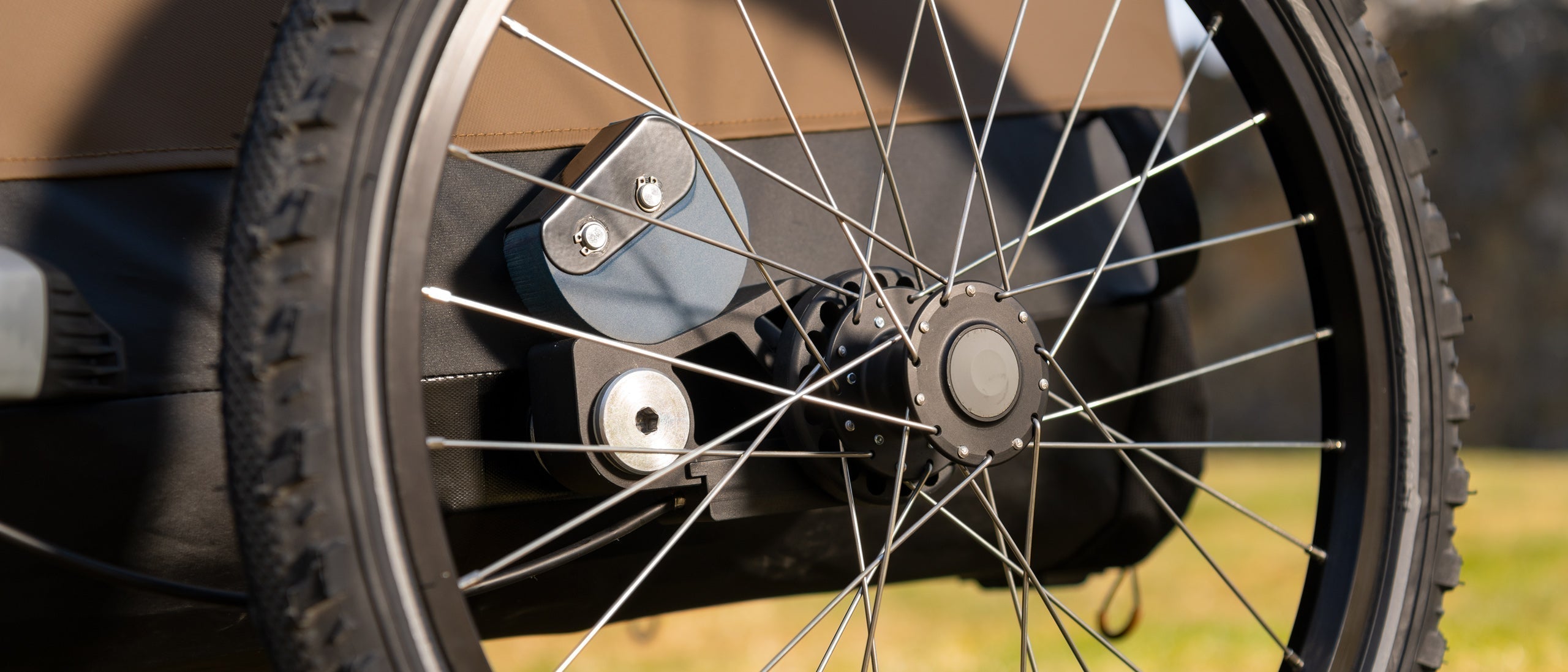 Croozer Airpad suspension on a dog trailer, in meadow with rocks.