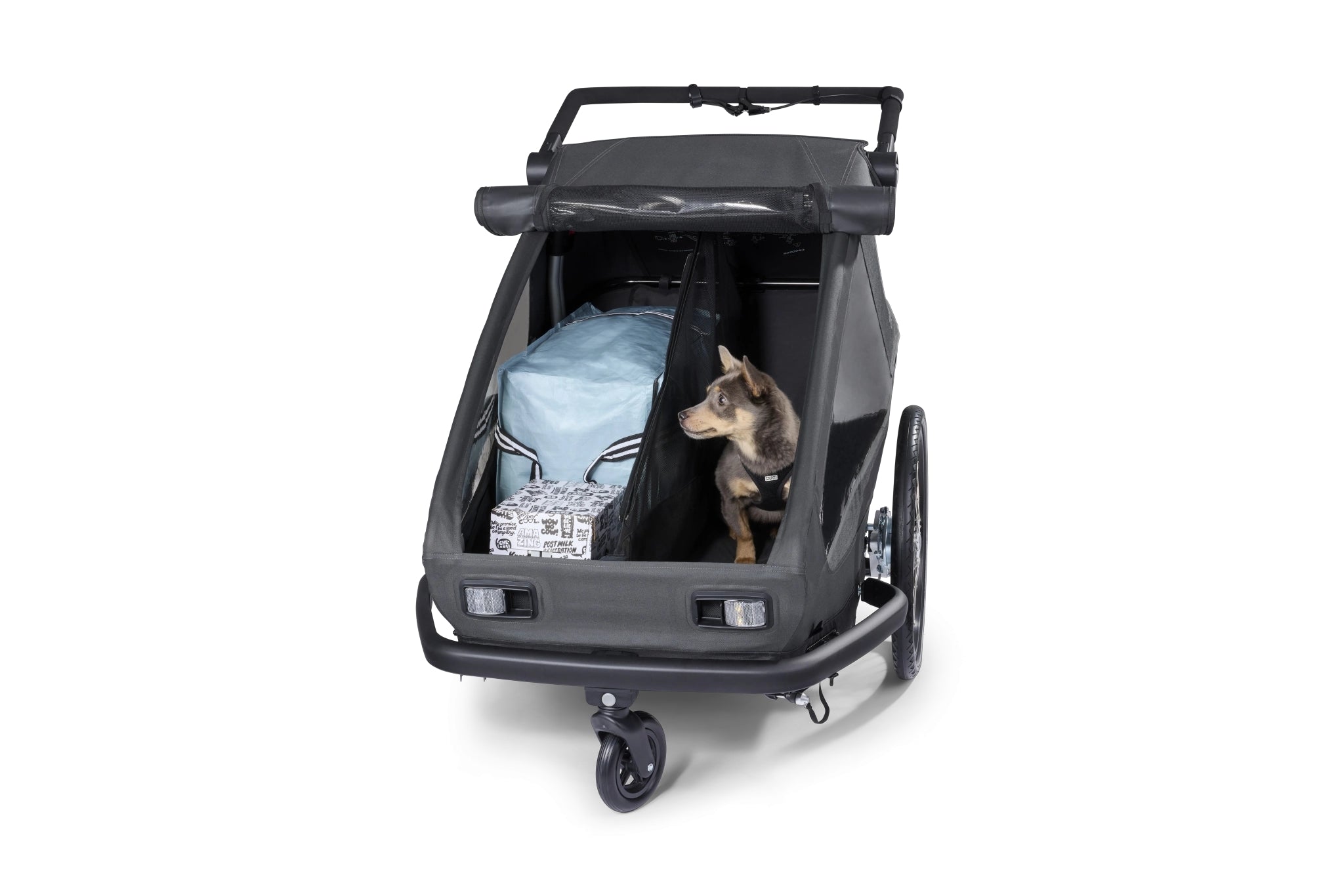 Croozer Yuuna modularity featuring dog in dog module on one side and luggage in cargo module on other side, separated by divider net
