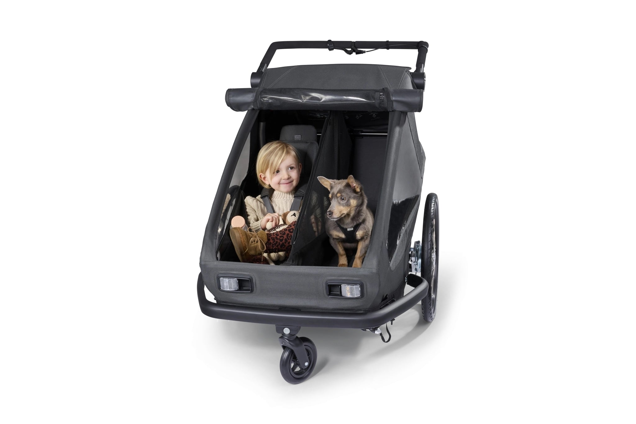 Croozer Yuuna modularity with child in premium seat module on one side and dog in dog module on other side, separated by partition net