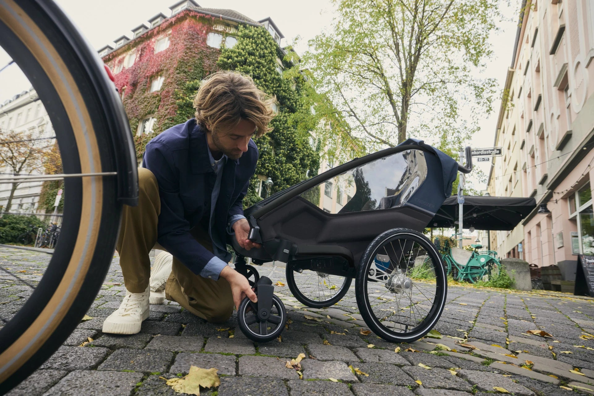 Buggyrad wird an den Kinderanhänger Lykke von Mann montiert.