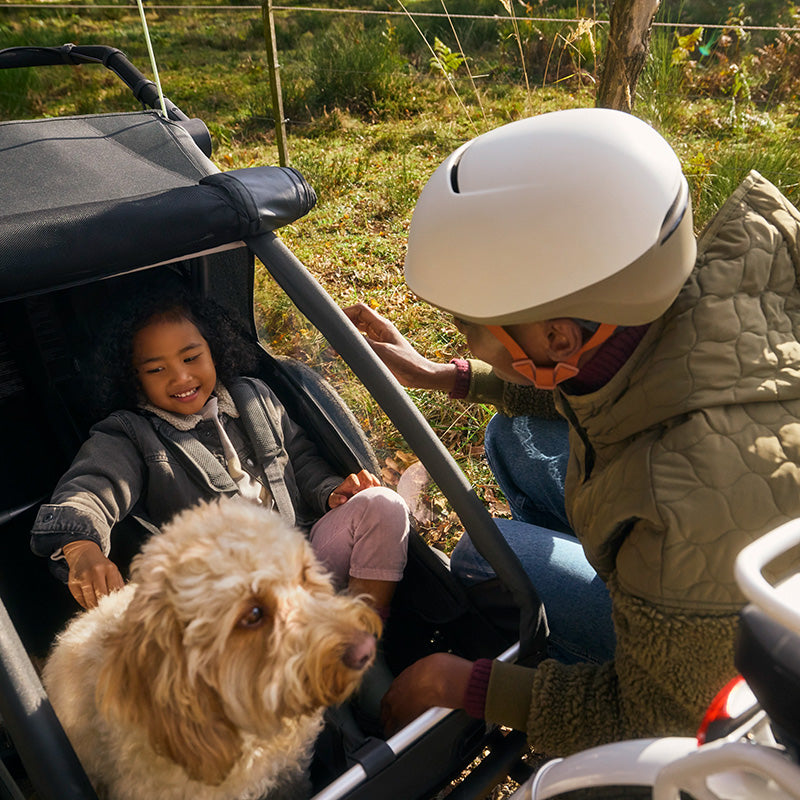 Mutter, Tochter und Hund gemeinsam unterwegs mit modularem Fahrradanhänger Croozer Yuuna