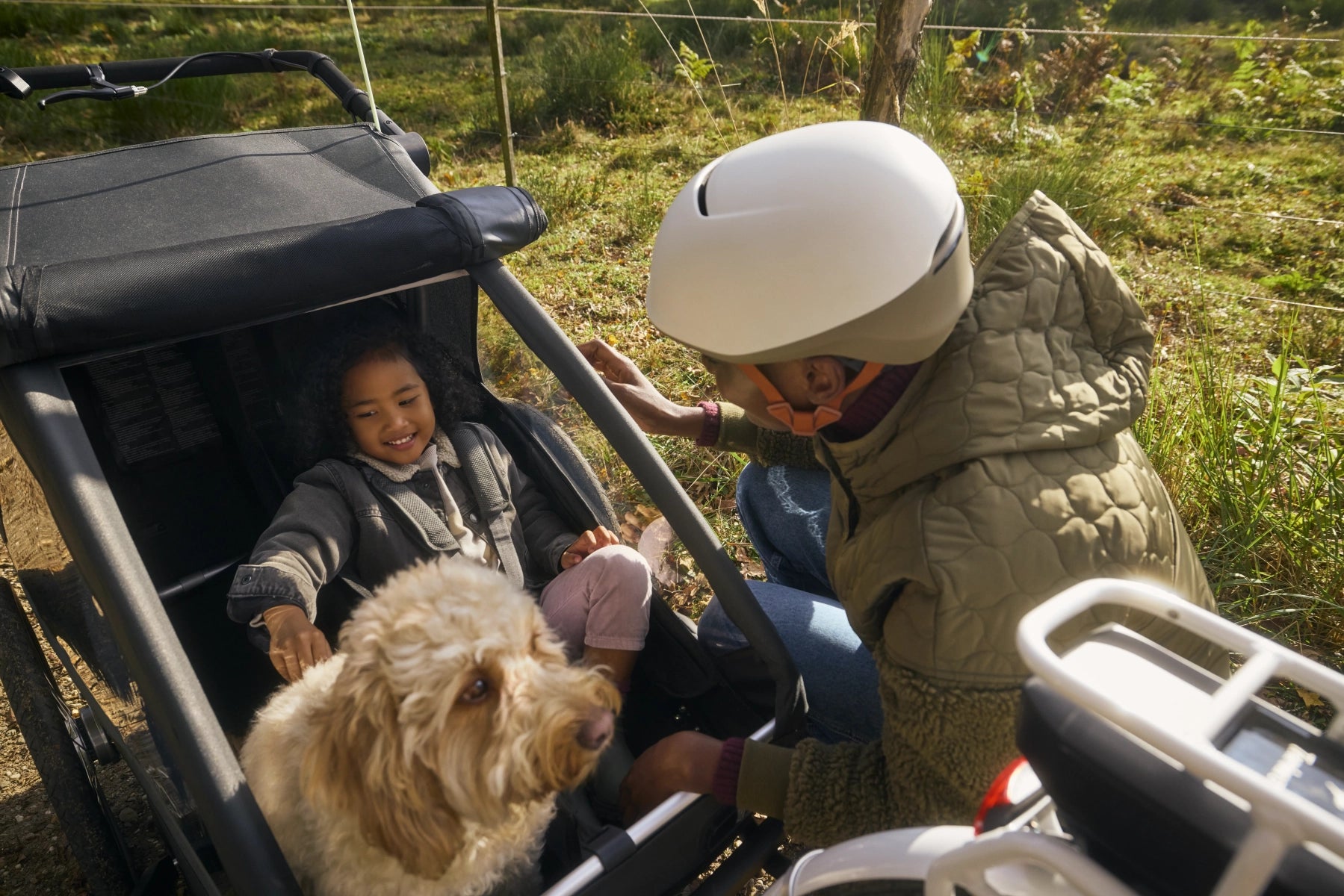 Mutter, Tochter und Hund gemeinsam unterwegs mit modularem Fahrradanhänger Croozer Yuuna