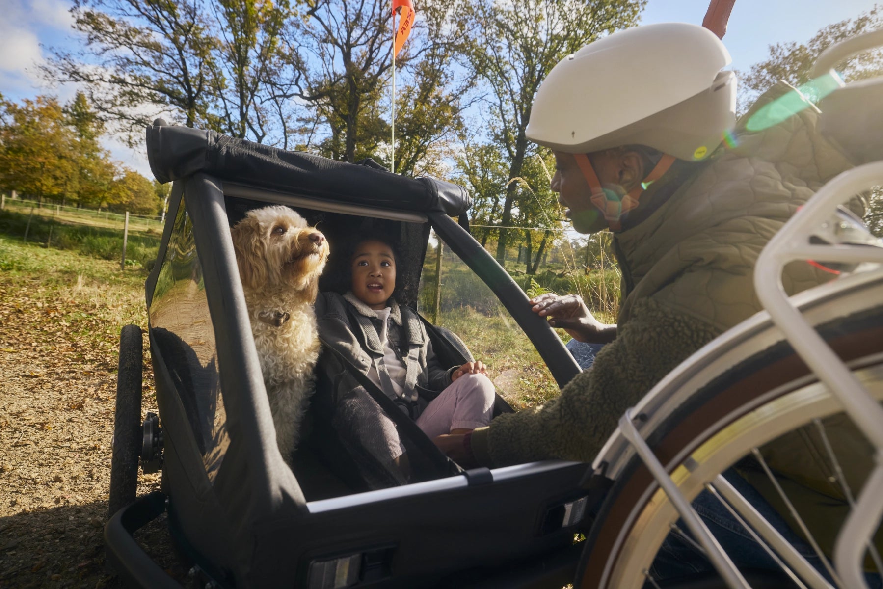 Kind und Hund gespannt auf Fahrt mit modularem Anhänger Croozer Yuuna