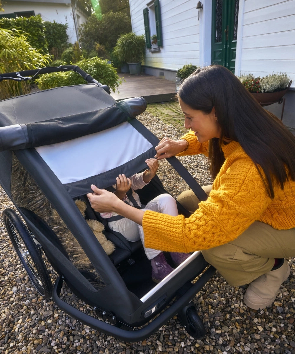 Mutter schützt Kind im Croozer Yuuna mit integriertem Sonnenschutz