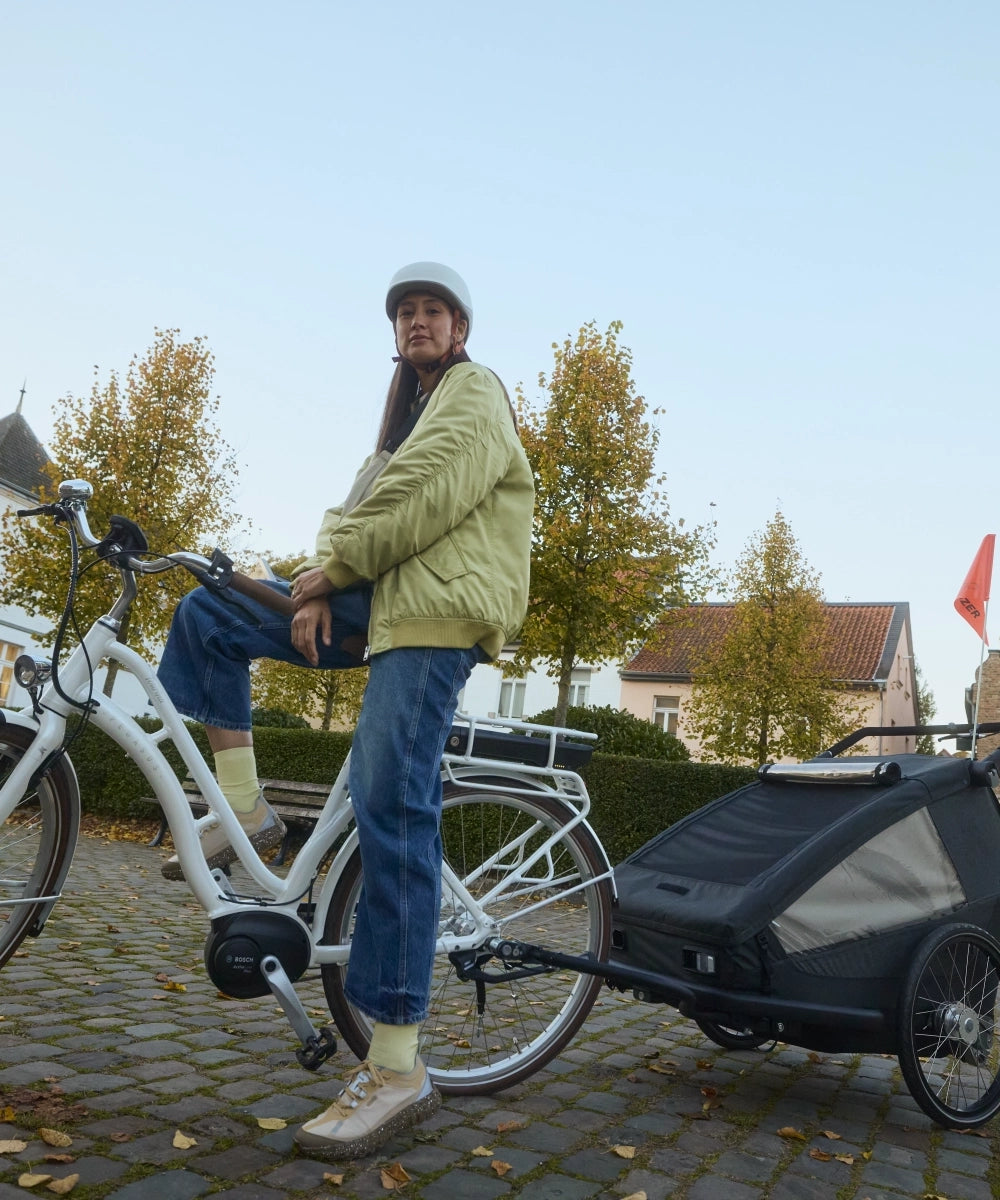 Frau mit Croozer Yuuna in historischer Altstadt unterwegs