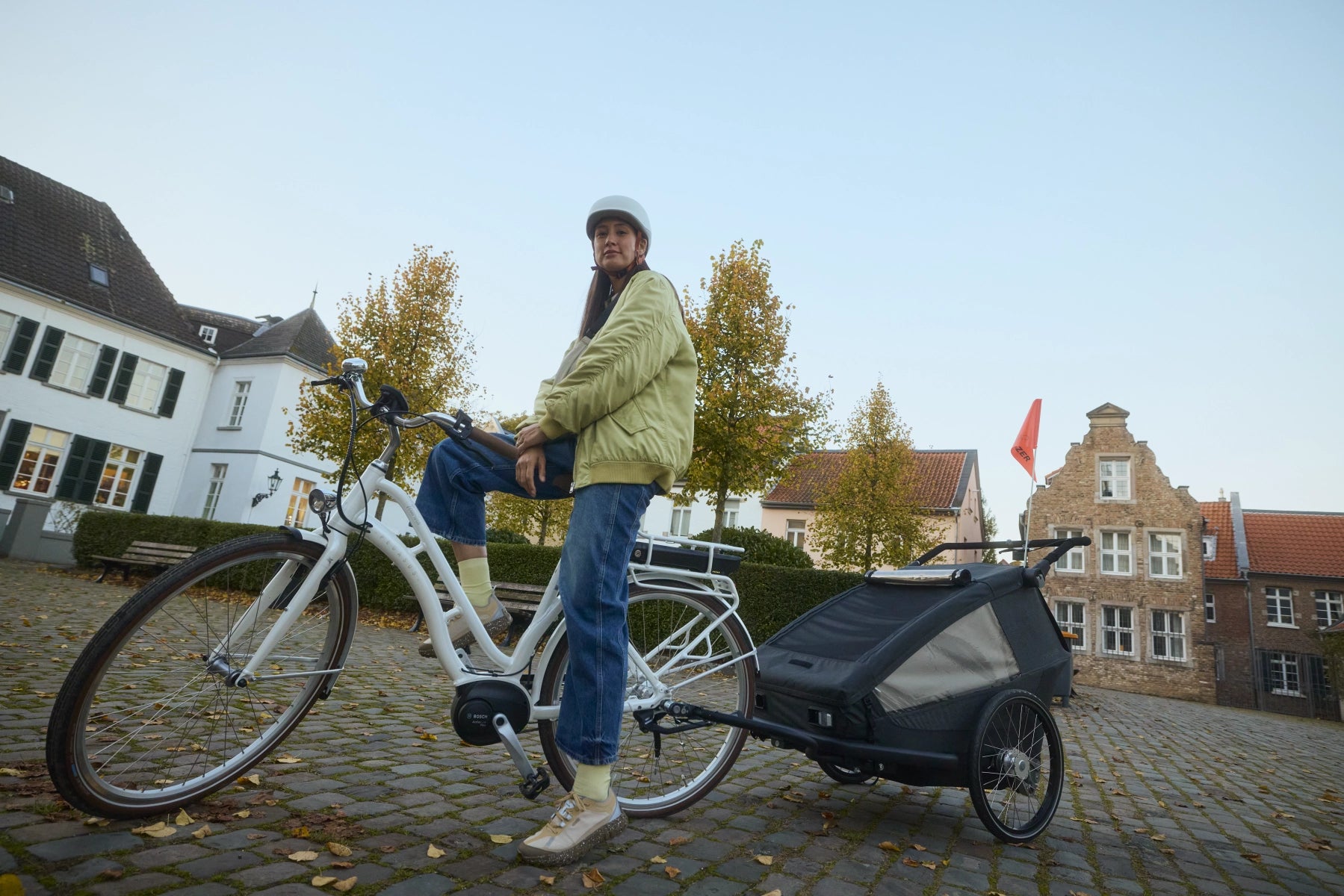 Frau mit Croozer Yuuna in historischer Altstadt unterwegs