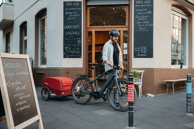 Man with Croozer cargo bike trailer at local restaurant - sustainable urban transport for dining and errands