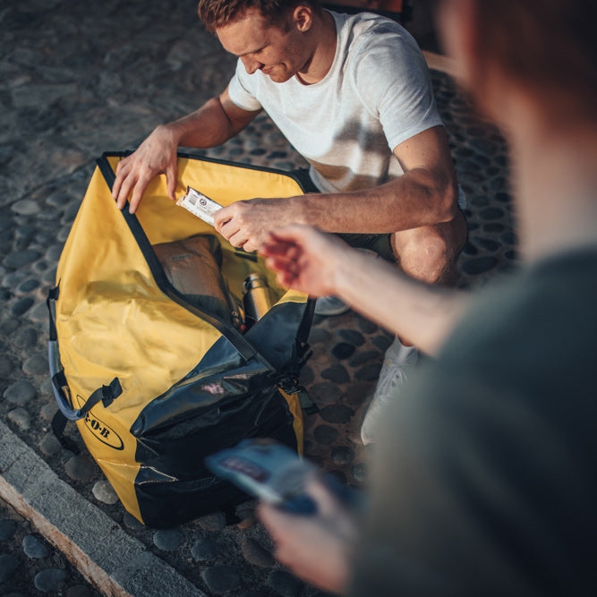 Couple preparing for a bike trip - packing their BOB Bag for cargo bike trailer