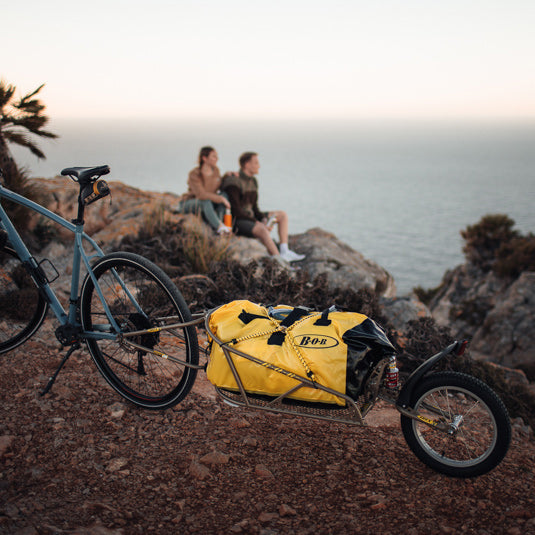 Couple taking a break from their bike tour - BOB cargo trailer with BOB bag and resting aside