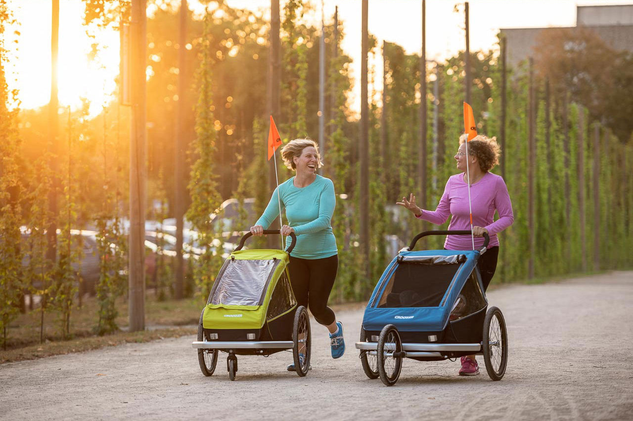 Two women participating in Laufmamalauf with Croozer Kid trailer functioning as jogger or buggy