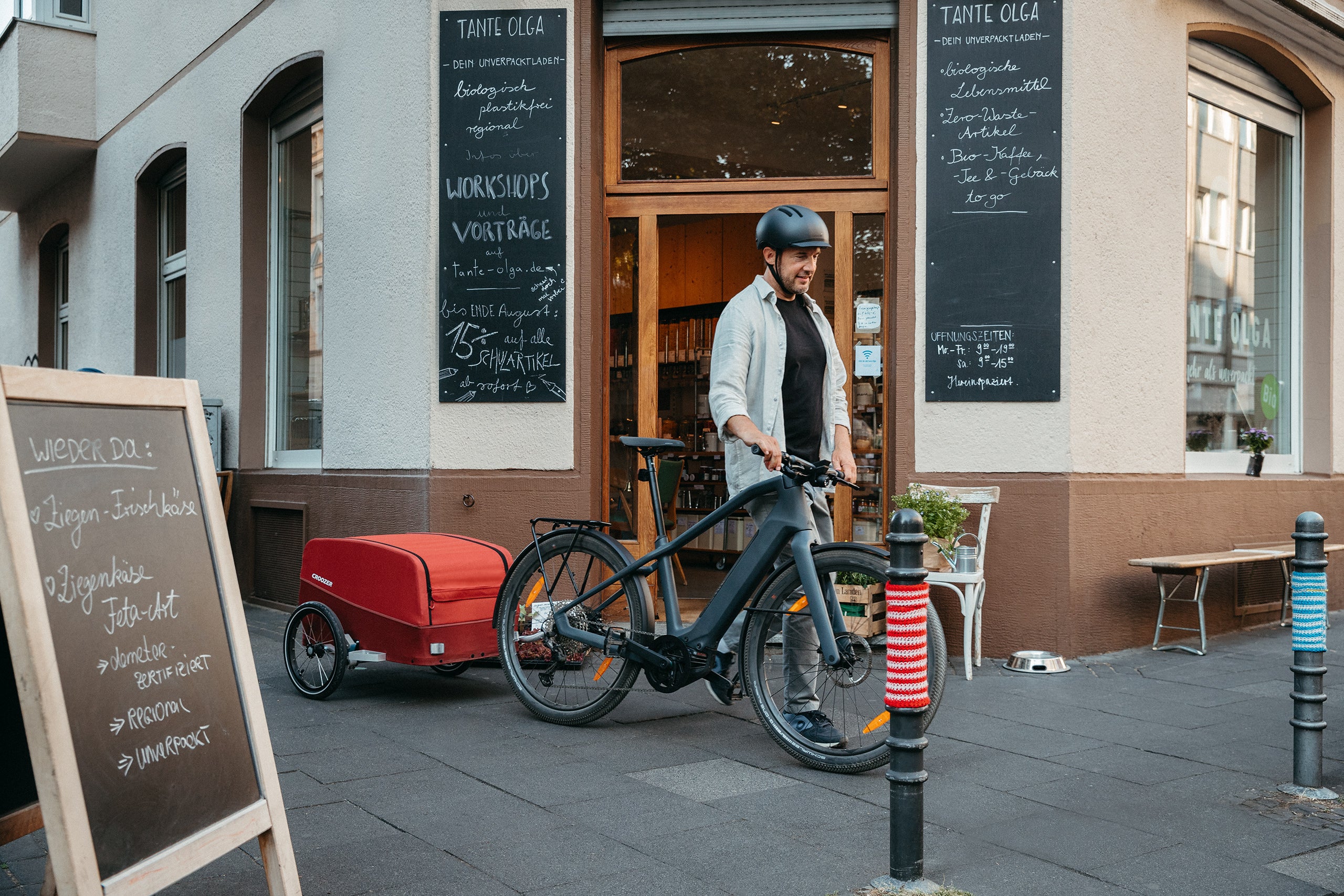 Man with Croozer Cargo in front of local store for groceries