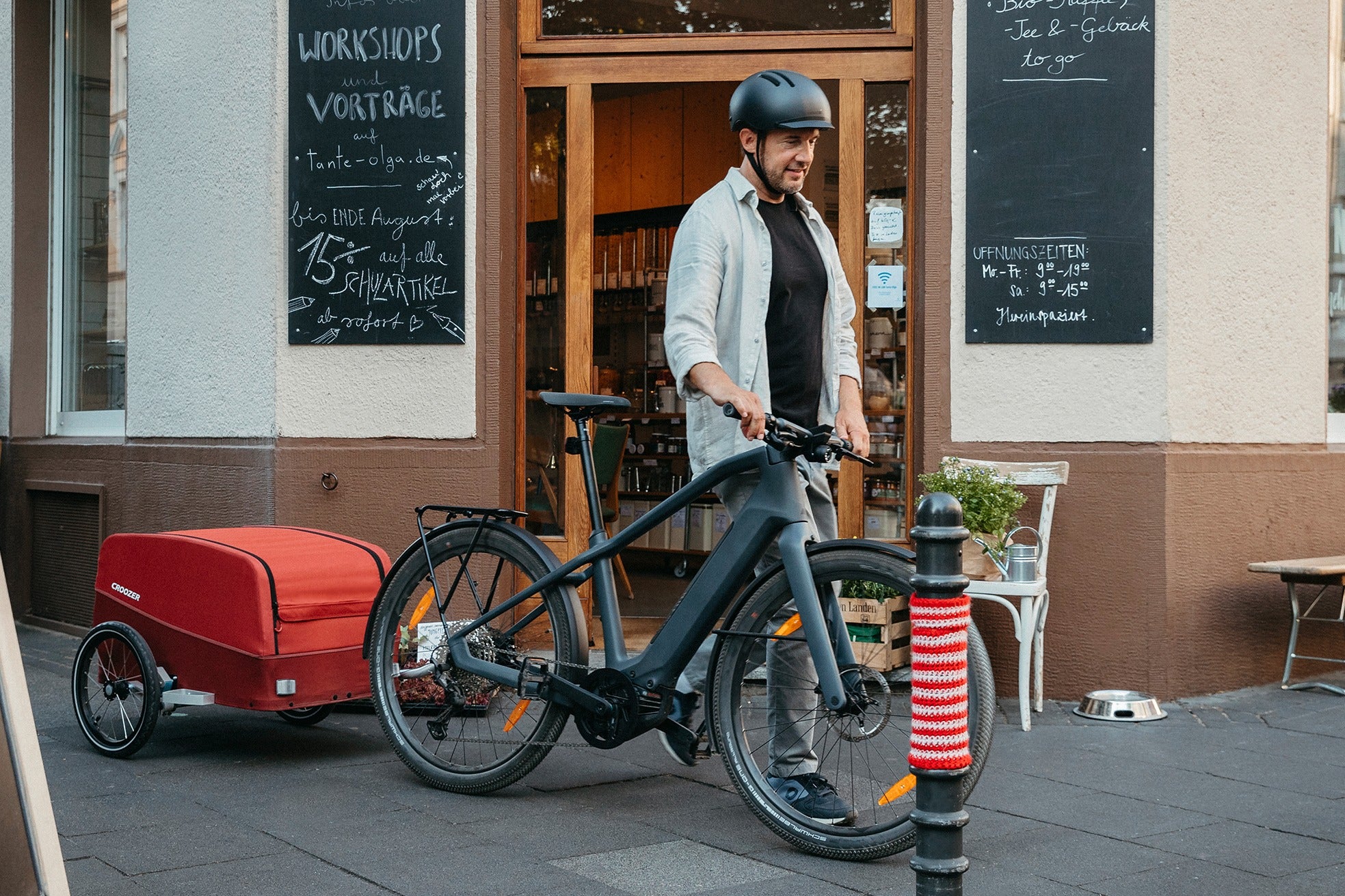 Man with Croozer Cargo in front of local store for groceries