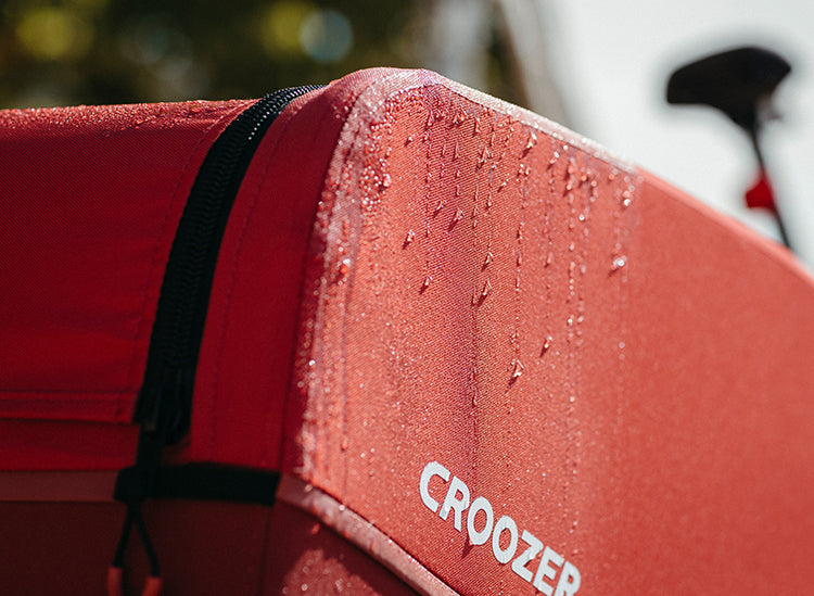 Croozer Cargo Tuure being water-proof, showing drops of water on the side