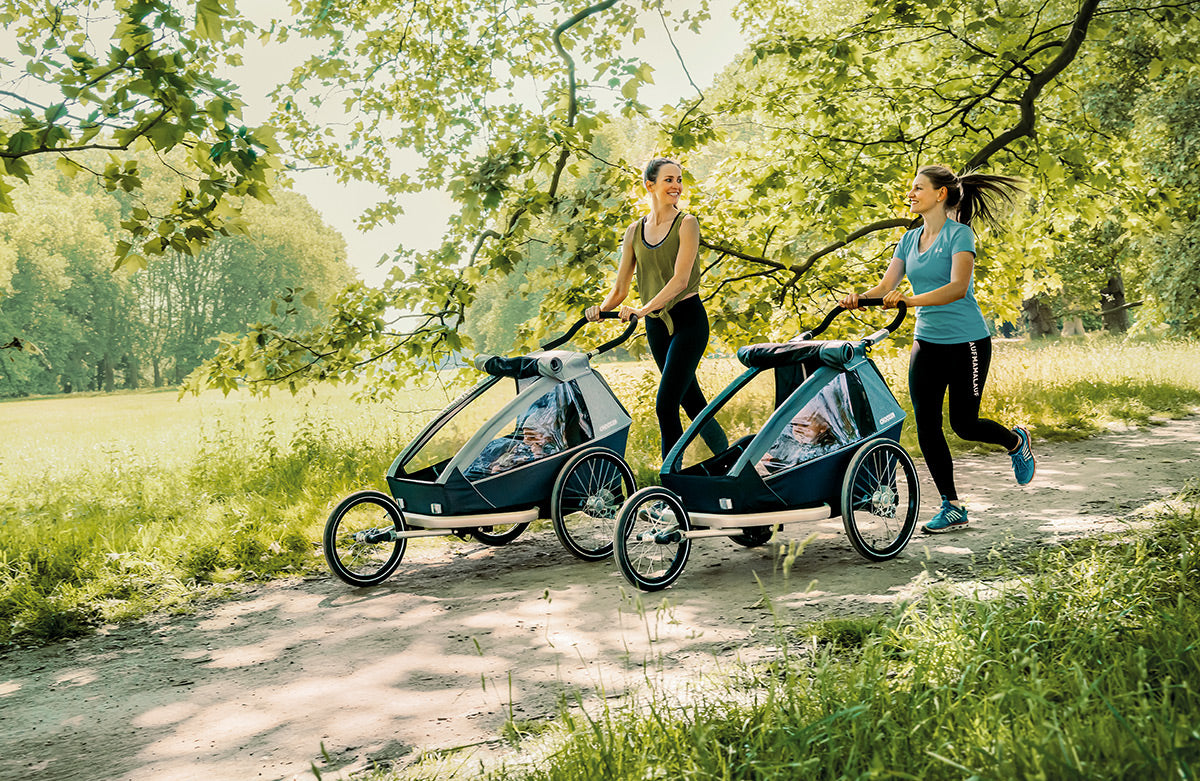 Two mothers jogging with their kids in Croozer Kid Keeke and Vaaya