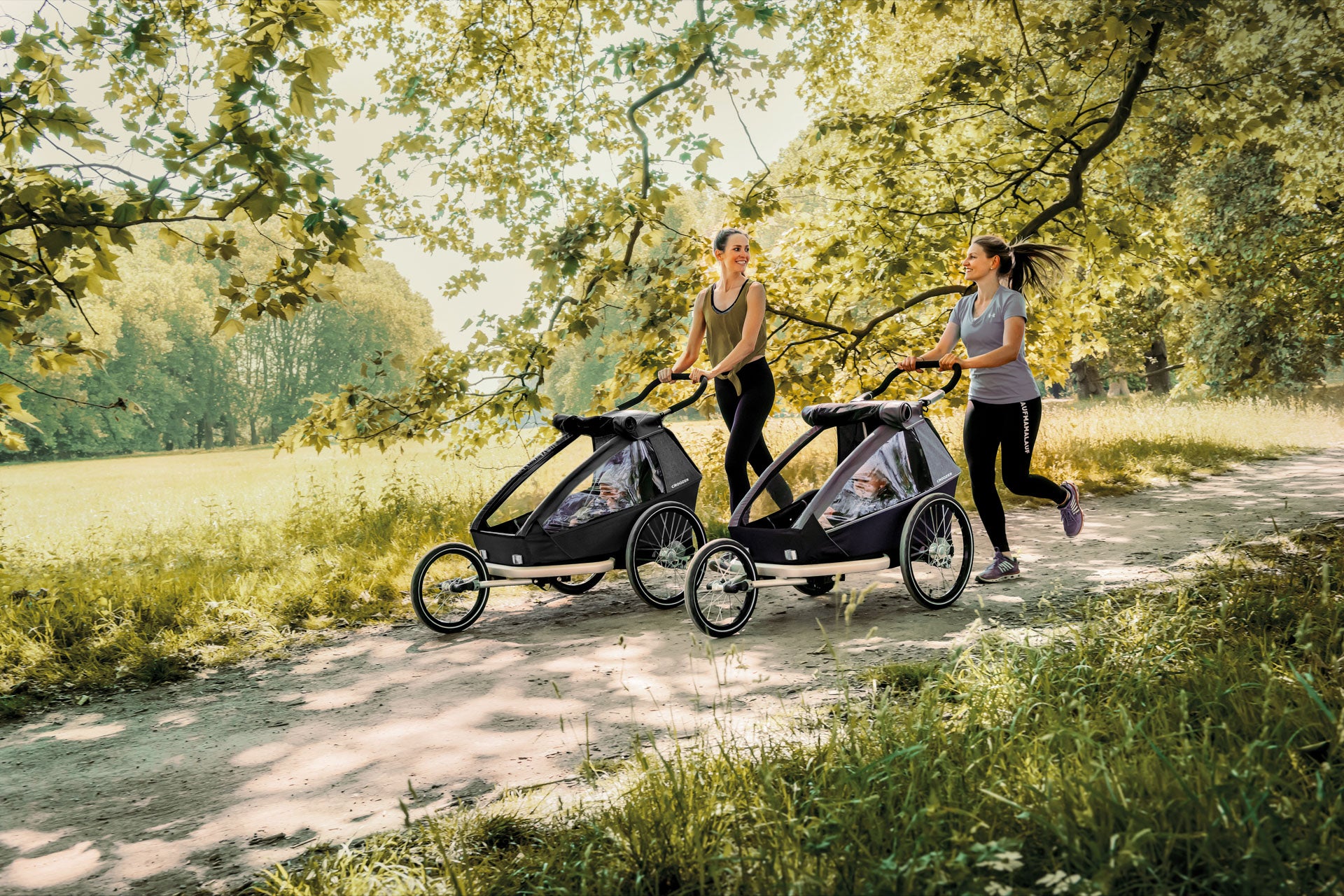Two mothers jogging with their kids in Croozer Kid Keeke and Vaaya