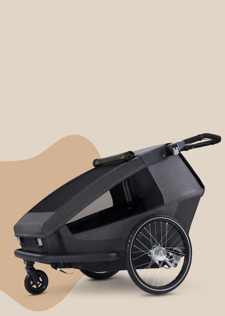 Croozer Yuuna modular bike trailer in moonlight black in stroller mode on beige background