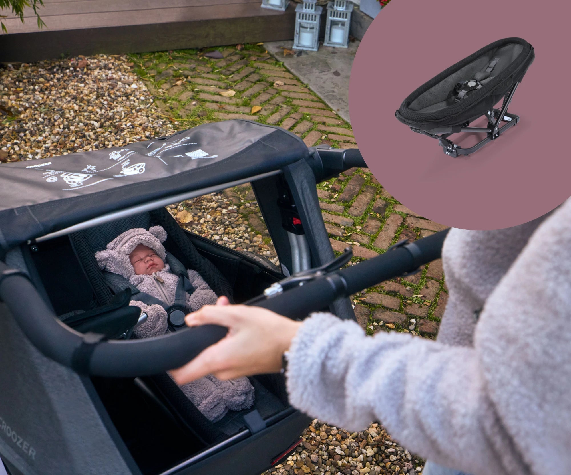 Parent pushing Croozer Yuuna bike trailer containing a baby in the baby seat module on cobblestone with product picture on the top right