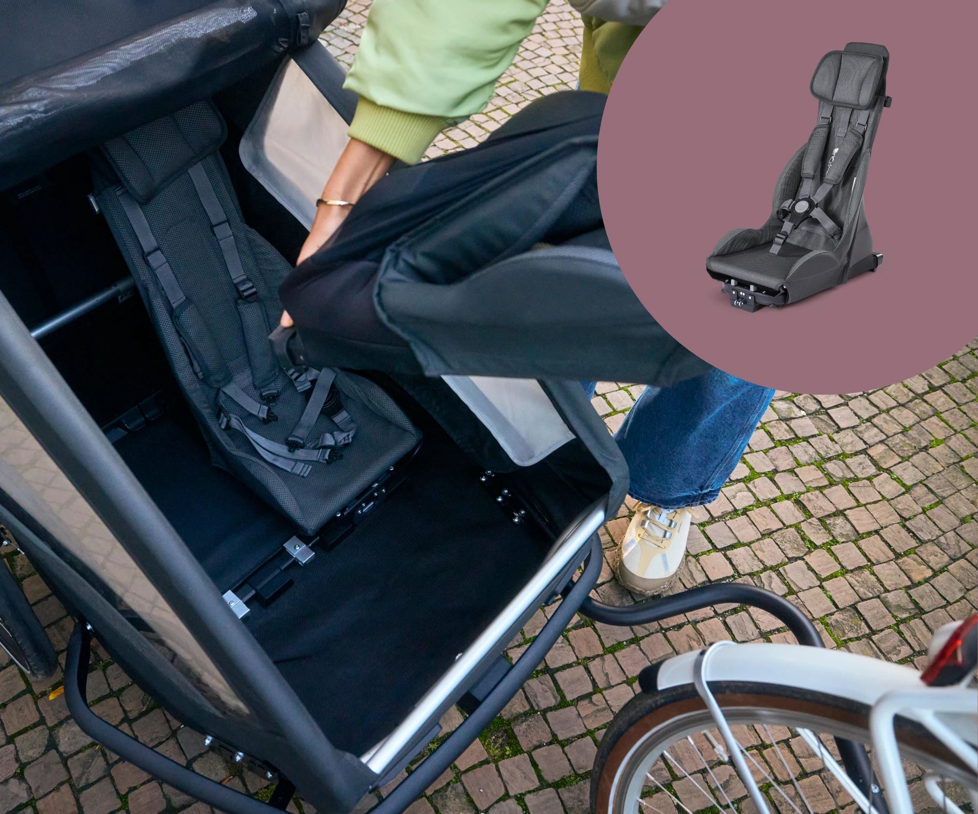 Croozer Yuuna premium seat module black with safety harness beeing installed in bike trailer with product picture on the top right