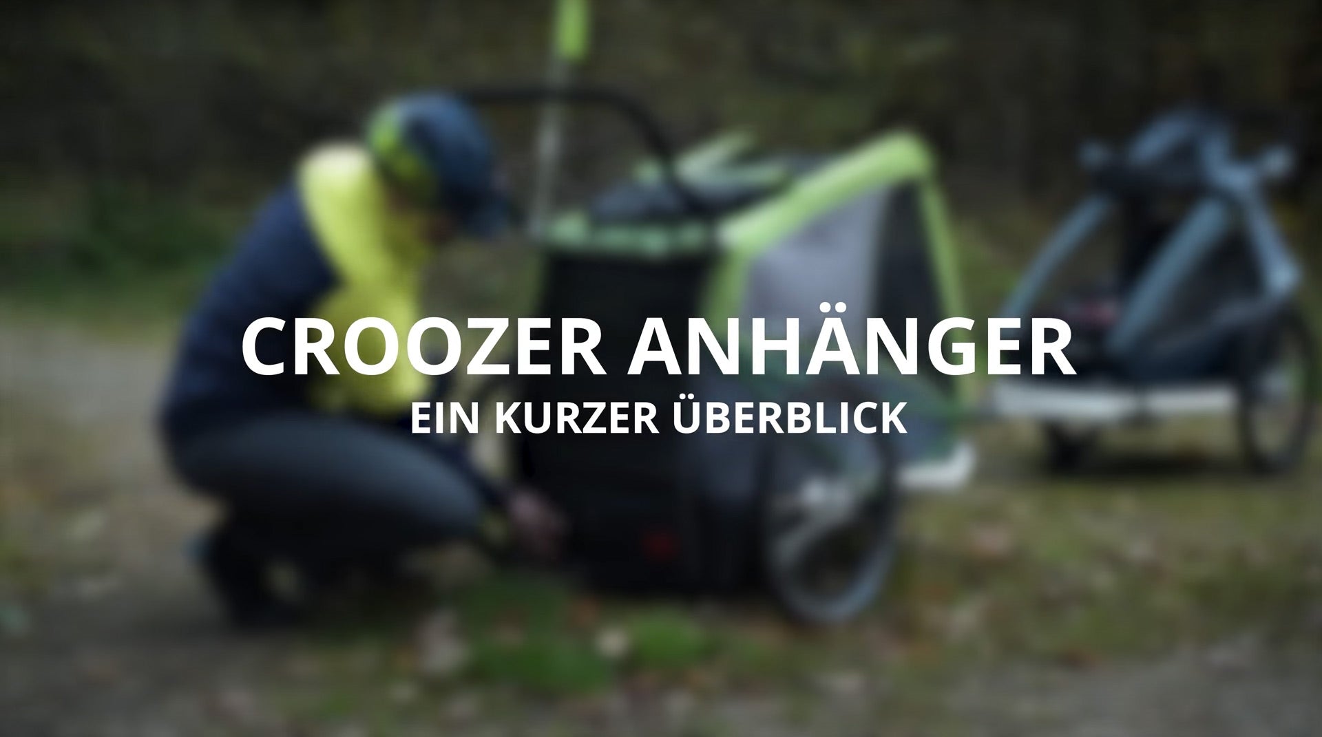 Croozer trailer overview text overlay with cyclist and bike trailer in background outdoor scene