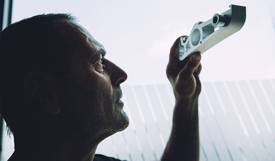 Croozer prototype builder examining bike trailer component in development workshop for testing and optimization