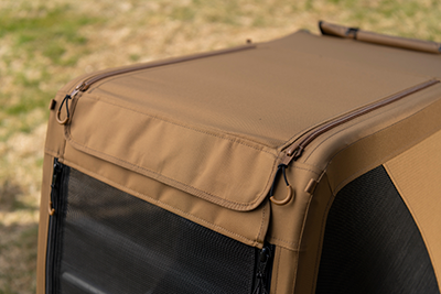 Fabric detail of dog bike trailer showing brown material with mesh window and zipper opening